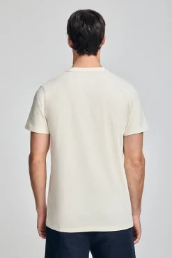 Camiseta color crudo de cuello redondo y logo engomado