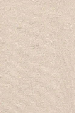Jersey de punto beige con cuello elevado y detalle de botón nacarado PC
