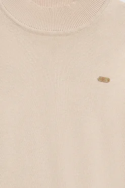 Jersey de punto beige con cuello elevado y detalle de botón nacarado PC