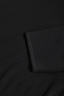 Jersey negro de cuello redondo con detalle de botón nacarado
