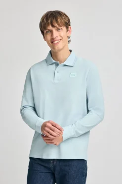 Polo azul claro de manga larga y dos botones con parche logotipado