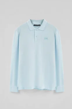 Polo azul claro de manga larga y dos botones con parche logotipado