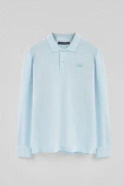 Polo azul claro de manga larga y dos botones con parche logotipado