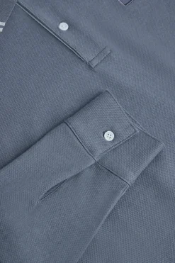Polo azul denim de manga larga y dos botones con parche logotipado