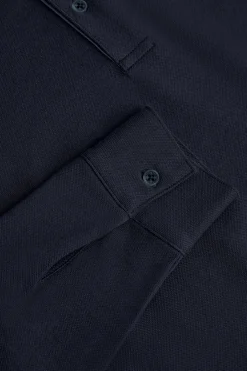 Polo azul marino de manga larga y dos botones con parche logotipado