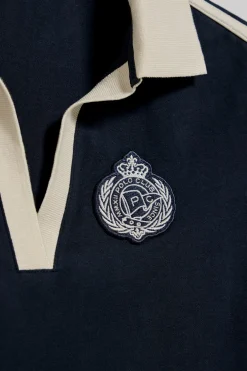 Polo azul marino sin botones y escudo náutico