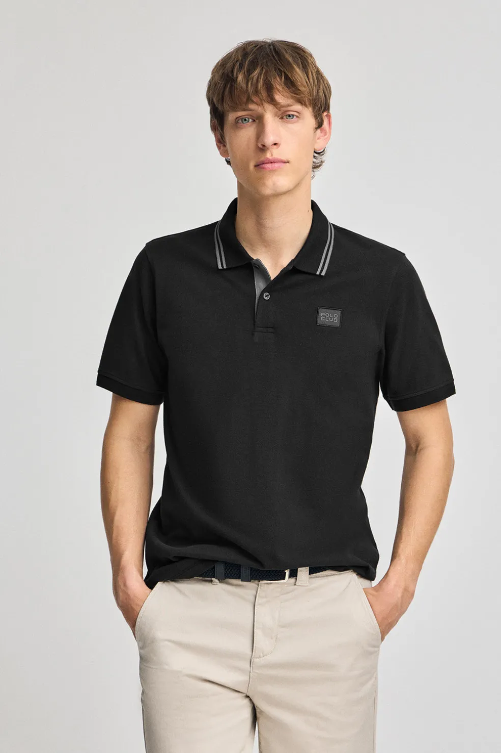 Polo negro de manga corta y dos botones con detalle en el pecho