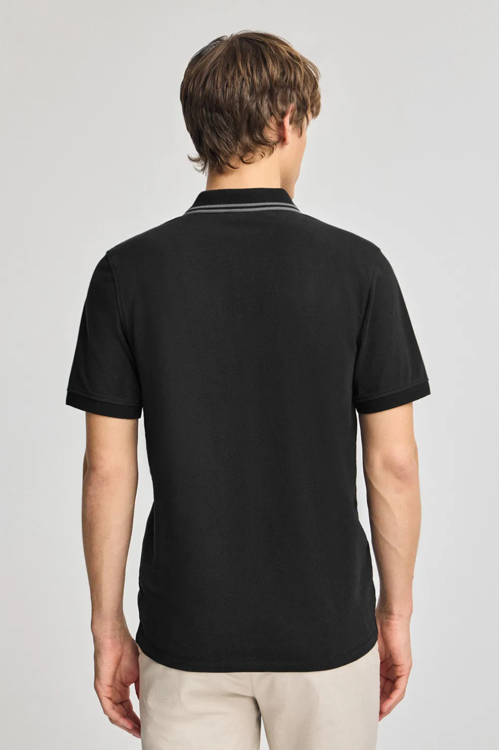 Polo negro de manga corta y dos botones con detalle en el pecho