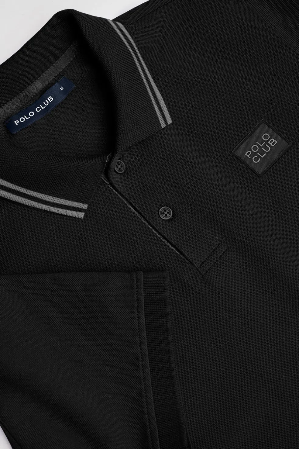 Polo negro de manga corta y dos botones con detalle en el pecho