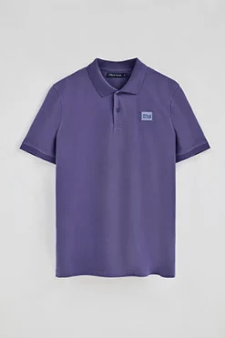 Polo violeta azulado de manga corta y dos botones con detalle en el pecho